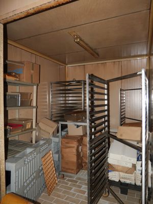 une pièce où se trouvent tout un tas d'étagères et de cartons