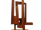 wooden sculpture of a chair on a wooden base on a white background