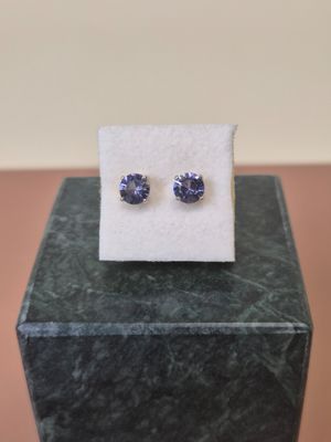 a pair of blue sapphire earrings sitting on top of a marble block