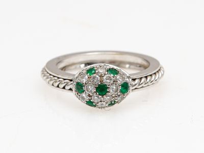 une bague en or blanc sertie d'une émeraude et de diamants
