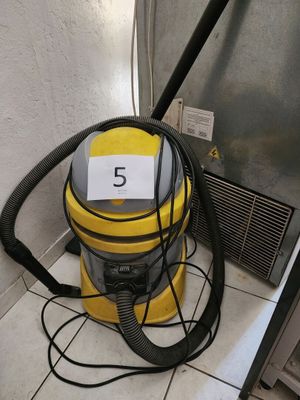 a yellow vacuum cleaner sitting on the floor next to a door