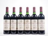 six bouteilles de vin sont alignées sur une surface blanche