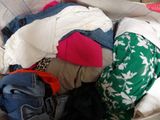 a basket full of clothes that is sitting on the floor