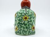 an image of a small green and yellow bottle with a red top