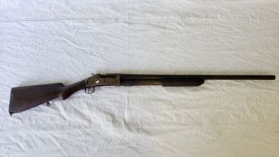 un fusil de chasse posé sur un drap blanc