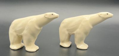 paire de figurines d'ours polaires en céramique blanche posées sur un fond noir