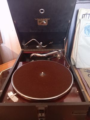 un vieux tourne-disque posé dans une valise sur une table
