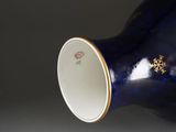 a blue vase with a gold decoration on it