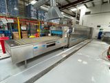 un tapis roulant dans une usine où il y a beaucoup de cartons