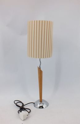 un gros plan d'une lampe posée sur une table, dont le cordon est branché