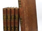 trois vieux livres sont empilés sur une surface blanche