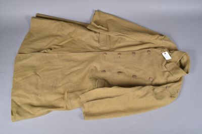 une photo d'une veste beige posée sur une table blanche