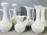 cinq vases blancs posés les uns à côté des autres sur une table