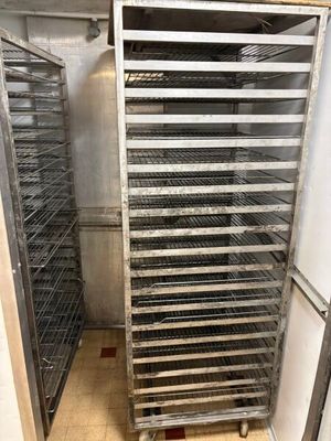 a metal rack with many trays of food inside of it