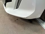 a close up of a car ' s front bumper with a flat tire