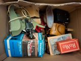une boîte en carton remplie d'objets divers et une paire de chaussures