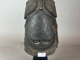 une photo d'une sculpture représentant une tête posée sur un socle noir