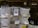 Des cartons de papier toilette sont empilés sur une palette dans un magasin