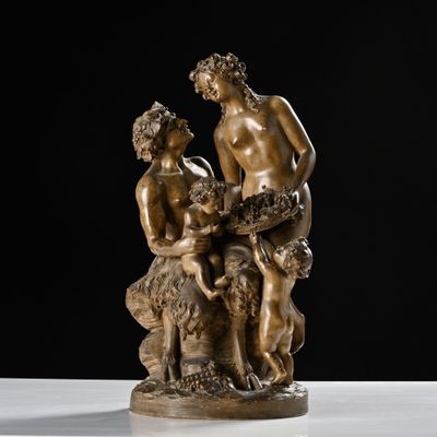 a bronze statue of a man and a woman sitting on a rock