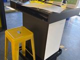 a desk with a yellow stool in front of it