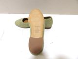 pair of women ' s green slippers on a white surface