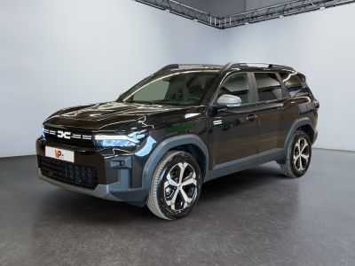 Le SUV noir est garé dans une grande pièce aux murs blancs.