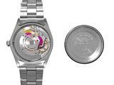 a watch and a coin sitting next to each other
