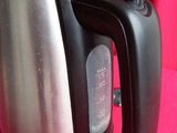 a silver and black electric kettle on a pink table