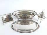 une assiette en argent et un plateau en argent posés sur une table blanche