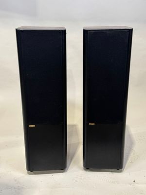deux enceintes noires posées sur une surface blanche