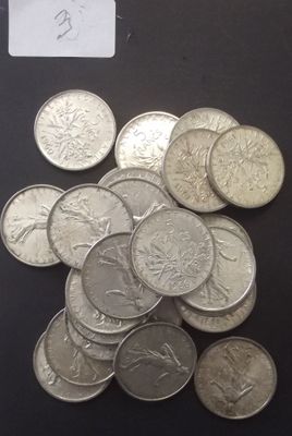 un tas de pièces d'argent posées sur une table, avec une étiquette indiquant le prix