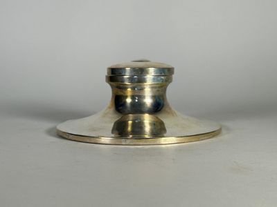un bougeoir en argent posé sur une table blanche