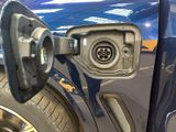 a close up of a blue car with an electric charger on it ' s side