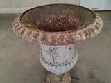 a rusted bowl sitting on top of a cement pedestal