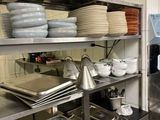 many plates and pans on the shelves in the kitchen