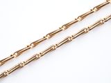 a close up of two gold chains on a white surface