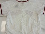 une chemise blanche à bordures rouges posée sur un plateau de table en marbre