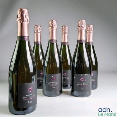six bouteilles de champagne sont alignées sur une table
