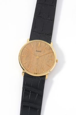 a close up of a watch on a black strap on a white surface