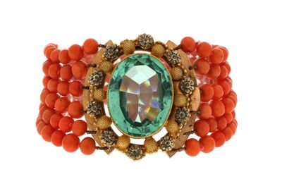 a close up of a bracelet with a green stone and orange beads