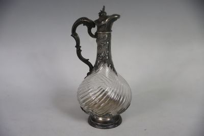 an antique silver plated glass pitcher on a white background