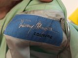 a person holding a blue and green jacket with a name on it