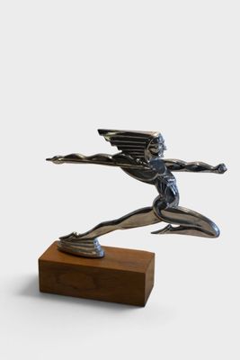 statue of a man with wings on a wooden base