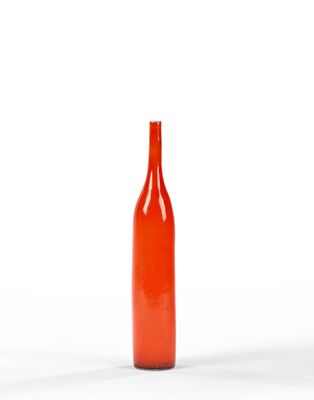 une image représentant une bouteille en verre rouge posée sur une surface blanche