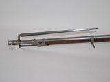 an old gun with a wooden handle on a white surface