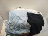 a pile of clothes in a white box on the floor