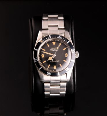a watch that is on display on a black surface