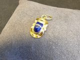 pendentif en or et lapis-lazuli, orné d'une pierre bleue posée sur un coussin