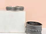 deux bracelets en argent posés sur un bloc de marbre blanc
