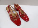 pair of red high heeled shoes on a white surface